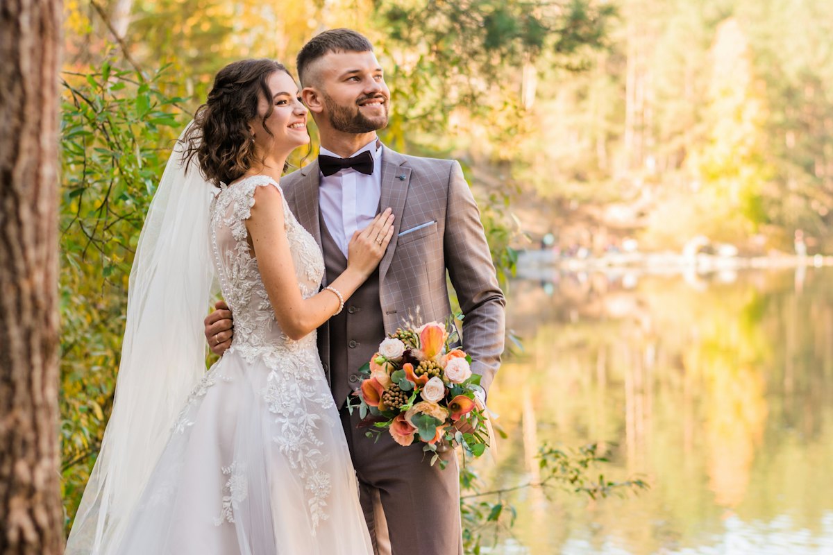 Novio de traje gris junto a la novia con vestido blanco
